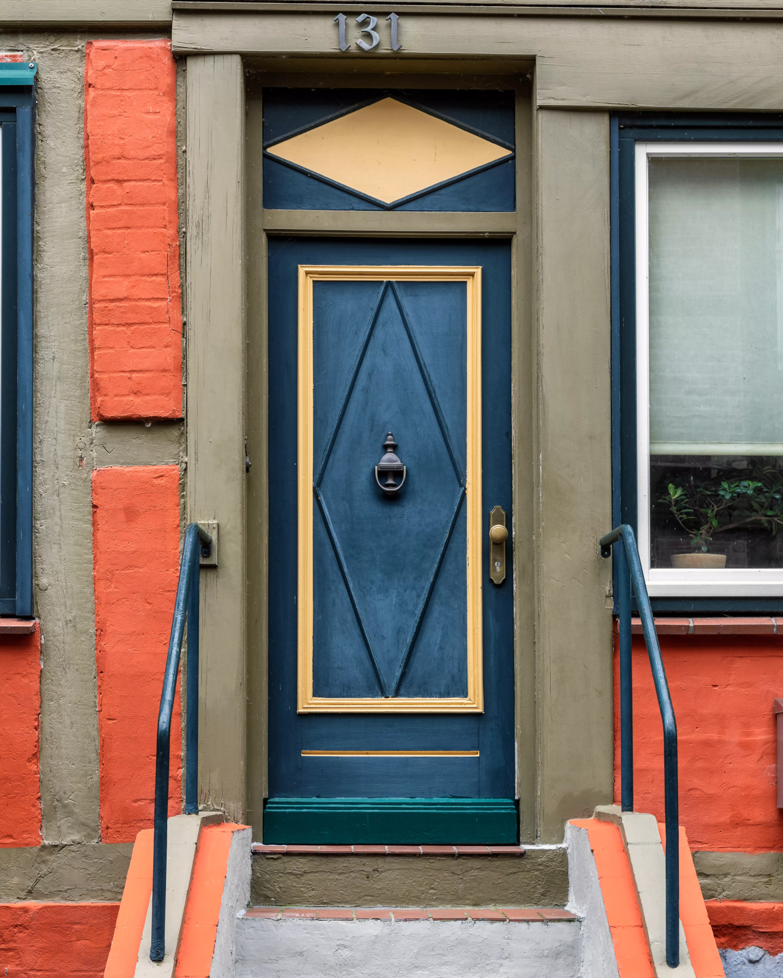 Escalier menant sur une porte d'entrée bleu.